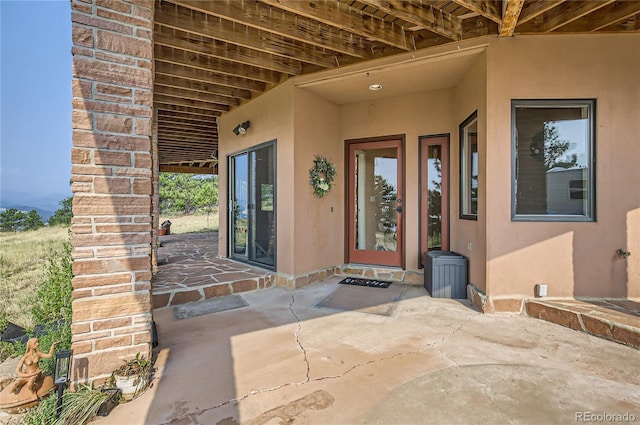 3001 Eagle Ridge Rd, Longmont, CO 80503 - doorway to property with stucco siding and a patio