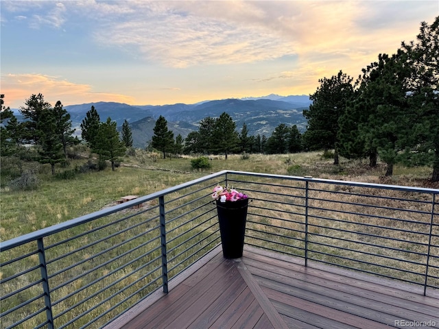 deck at dusk featuring a mountain view