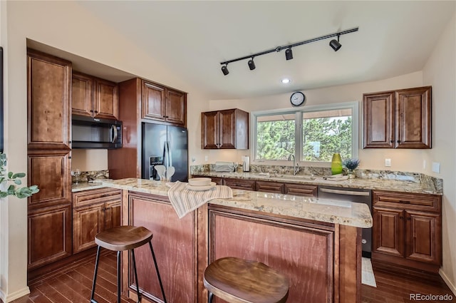 3001 Eagle Ridge Rd, Longmont, CO 80503 - kitchen with appliances with stainless steel finishes, a sink, rail lighting, a kitchen island, and dark wood-style floors