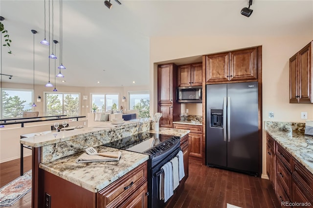 3001 Eagle Ridge Rd, Longmont, CO 80503 - kitchen with stainless steel appliances, dark wood-style flooring, light stone counters, brown cabinetry, and recessed lighting