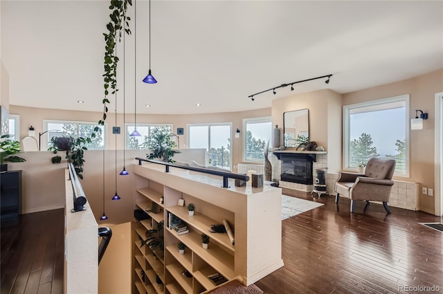3001 Eagle Ridge Rd, Longmont, CO 80503 - bar featuring a glass covered fireplace, dark wood finished floors, decorative light fixtures, recessed lighting, and rail lighting