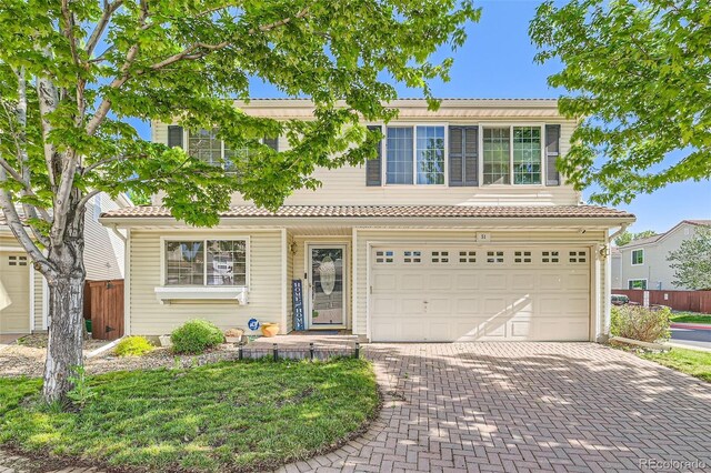 20000 Mitchell Pl Unit 51, Denver, CO 80249 - view of front of home with decorative driveway, an attached garage, fence, and a tiled roof