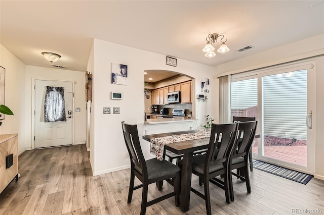 20000 Mitchell Pl Unit 51, Denver, CO 80249 - dining area featuring light wood-style floors, baseboards, and arched walkways