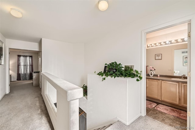 20000 Mitchell Pl Unit 51, Denver, CO 80249 - hallway featuring a sink, light colored carpet, and baseboards