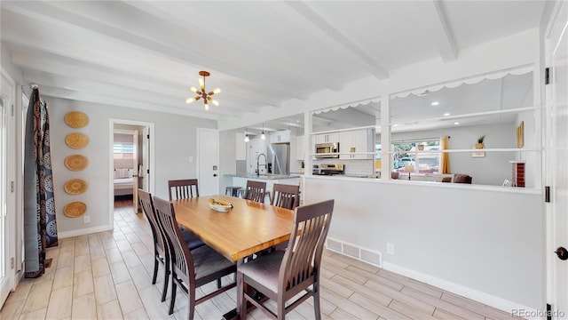 3067 S Holly Pl, Denver, CO 80222 - dining space featuring healthy amount of natural light, beam ceiling, a chandelier, wood finish floors, and baseboards