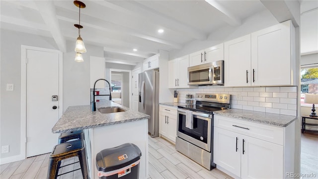 3067 S Holly Pl, Denver, CO 80222 - kitchen with stainless steel appliances, a sink, beam ceiling, backsplash, and light stone counters