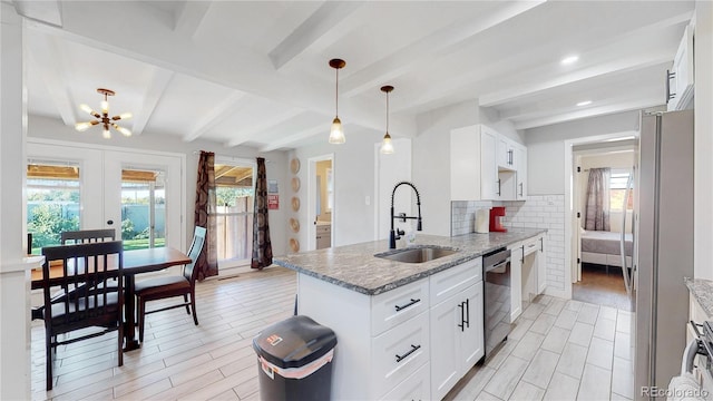 3067 S Holly Pl, Denver, CO 80222 - kitchen with a sink, appliances with stainless steel finishes, a chandelier, light stone counters, and tasteful backsplash