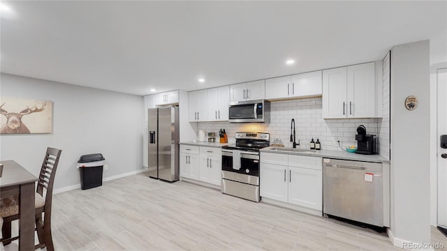 3067 S Holly Pl, Denver, CO 80222 - kitchen with stainless steel appliances, a sink, light countertops, backsplash, and white cabinets
