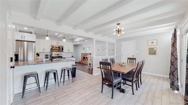 3067 S Holly Pl, Denver, CO 80222 - dining room with beam ceiling, light wood finished floors, baseboards, a chandelier, and recessed lighting