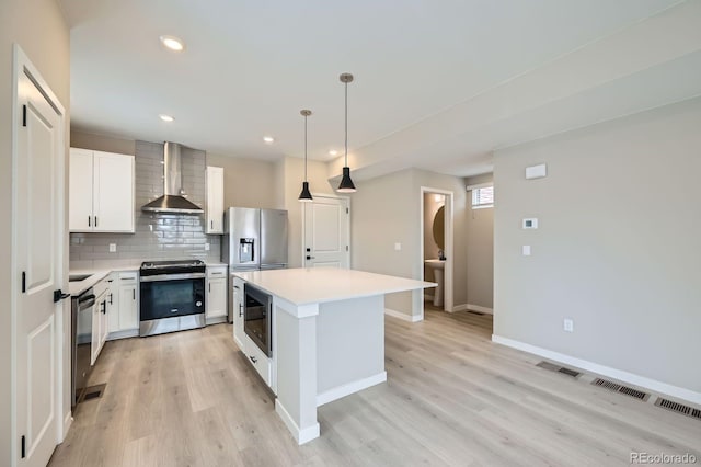 6926 Kendrick Ln, Arvada, CO 80007 - kitchen with appliances with stainless steel finishes, light countertops, wall chimney exhaust hood, tasteful backsplash, and a kitchen island