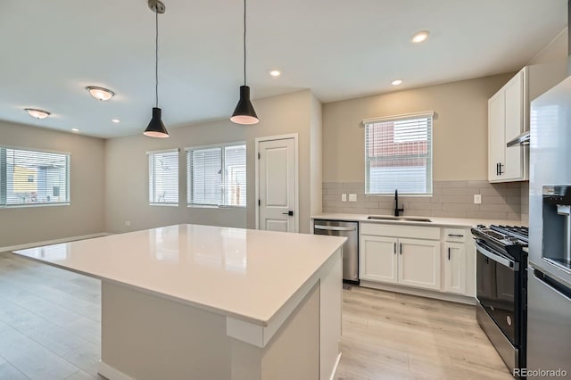 6926 Kendrick Ln, Arvada, CO 80007 - kitchen with light countertops, tasteful backsplash, a sink, light wood finished floors, and appliances with stainless steel finishes