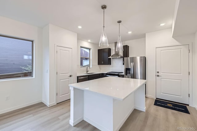 6926 Kendrick Ln, Arvada, CO 80007 - kitchen with stainless steel appliances, wall chimney exhaust hood, light wood finished floors, light countertops, and recessed lighting