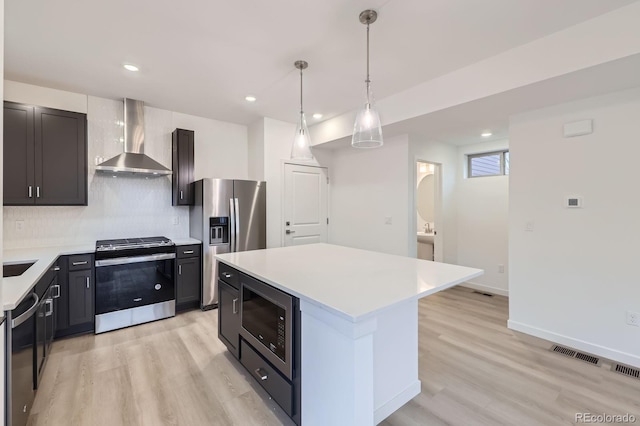 6926 Kendrick Ln, Arvada, CO 80007 - kitchen with wall chimney exhaust hood, appliances with stainless steel finishes, light countertops, light wood finished floors, and tasteful backsplash