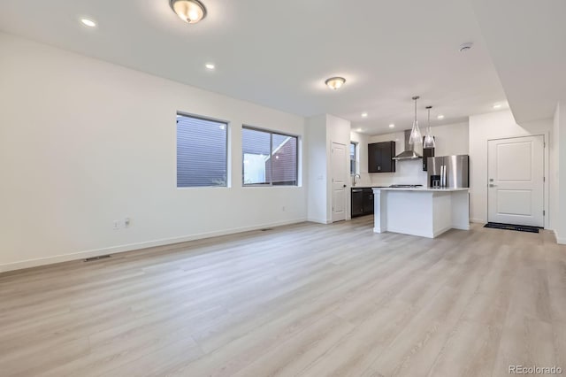 6926 Kendrick Ln, Arvada, CO 80007 - unfurnished living room featuring light wood-type flooring and recessed lighting