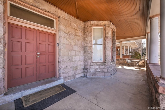 property entrance with stone siding and covered porch