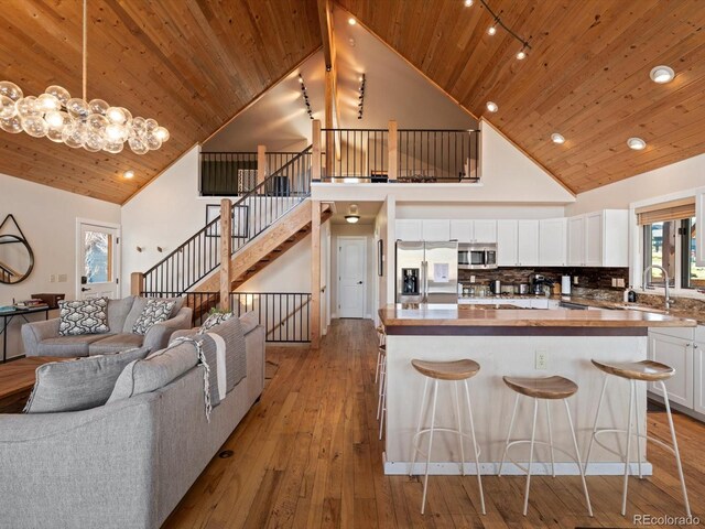 152 Bergamot Dr, Tabernash, CO 80478 - kitchen with stainless steel appliances, open floor plan, high vaulted ceiling, a sink, and white cabinetry