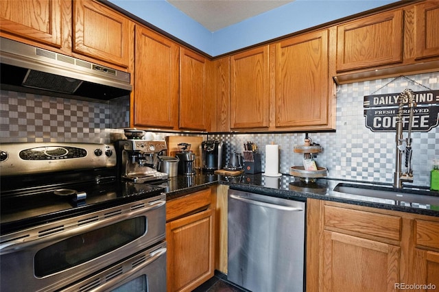 kitchen featuring tasteful backsplash, appliances with stainless steel finishes, and dark stone counters