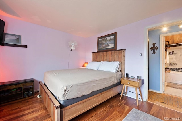 bedroom featuring a spacious closet, dark wood-type flooring, ensuite bathroom, and a closet