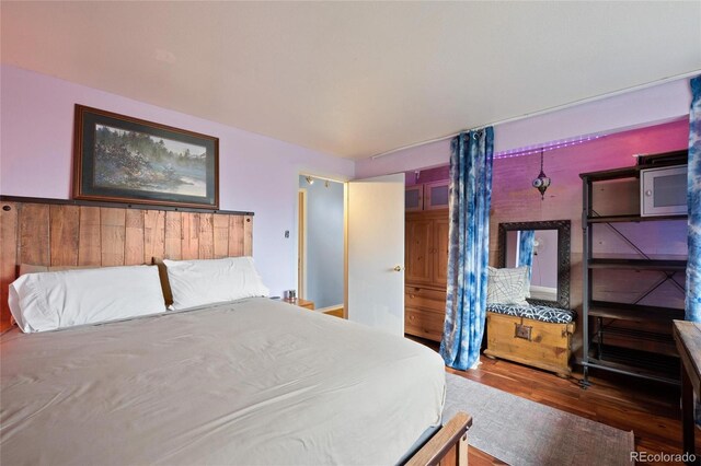 bedroom featuring wood walls and hardwood / wood-style floors