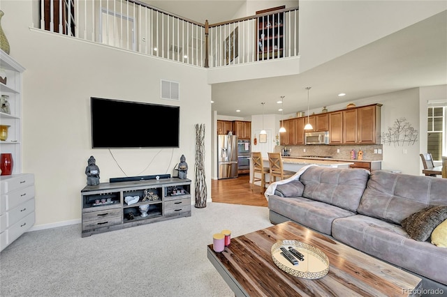 5722 S Flat Rock Way, Aurora, CO 80016 - living room featuring recessed lighting, light colored carpet, and a towering ceiling