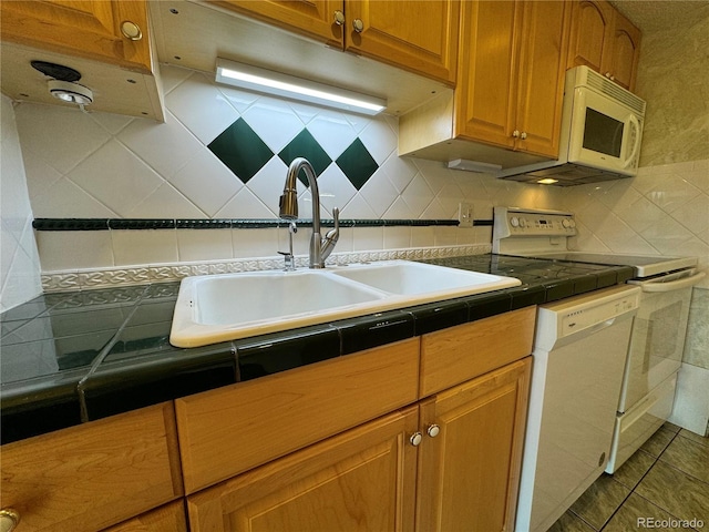 kitchen featuring tile counters, white appliances, sink, and tasteful backsplash