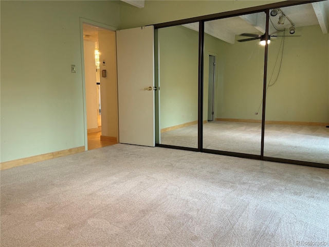 unfurnished bedroom with light carpet and a closet