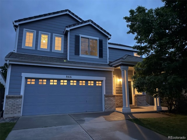 8416 S Reed St, Littleton, CO 80128 - view of front facade with brick siding, driveway, and an attached garage