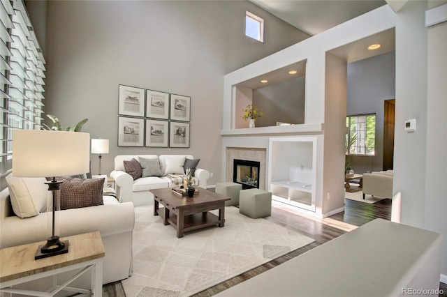 8416 S Reed St, Littleton, CO 80128 - living area featuring a towering ceiling, wood finished floors, a tiled fireplace, and recessed lighting