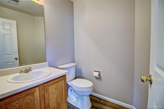 8416 S Reed St, Littleton, CO 80128 - half bathroom with toilet, baseboards, wood finished floors, and vanity