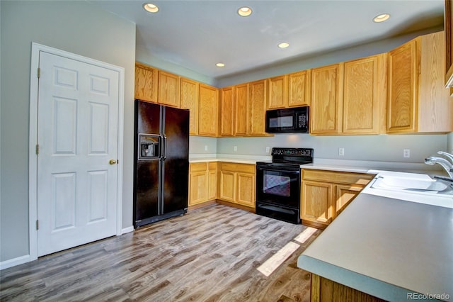 8416 S Reed St, Littleton, CO 80128 - kitchen with black appliances, a sink, light wood finished floors, recessed lighting, and light countertops
