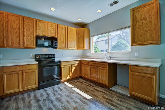 8416 S Reed St, Littleton, CO 80128 - kitchen featuring black appliances, dark wood-type flooring, light countertops, recessed lighting, and brown cabinets