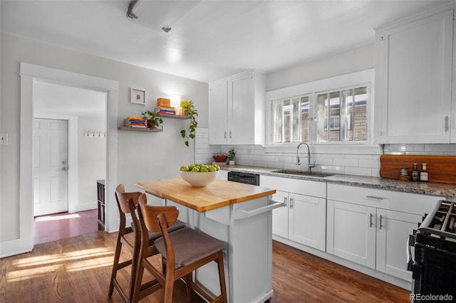 kitchen featuring black appliances, light stone countertops, sink, and white cabinets