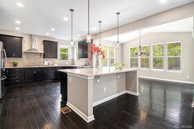 3522 Harvard Pl, Broomfield, CO 80023 - kitchen featuring a spacious island, dark wood finished floors, wall chimney exhaust hood, and cooktop