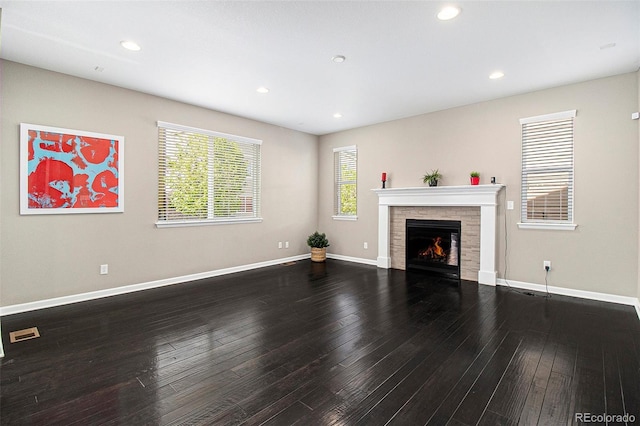 3522 Harvard Pl, Broomfield, CO 80023 - unfurnished living room featuring baseboards, a lit fireplace, wood finished floors, and visible vents