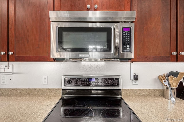 interior space with light stone countertops and stainless steel appliances