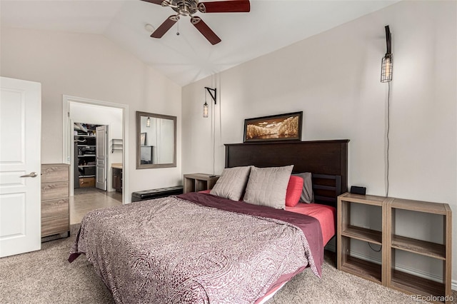 carpeted bedroom featuring ceiling fan, a closet, vaulted ceiling, and a spacious closet