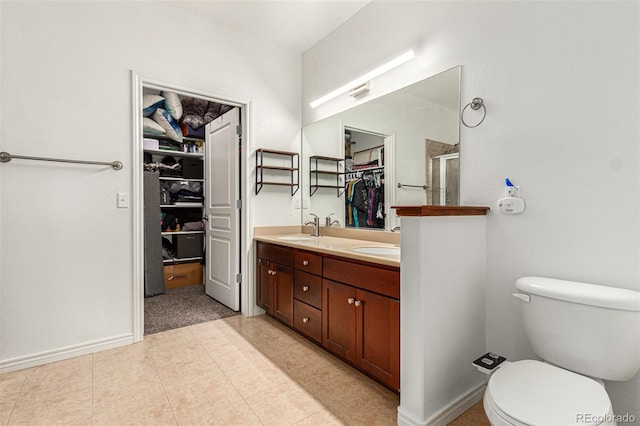 bathroom with vanity, tile patterned floors, a shower with shower door, and toilet