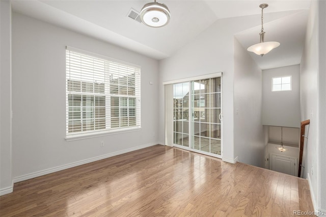 empty room with hardwood / wood-style floors and vaulted ceiling