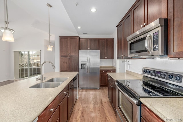 kitchen with sink, stainless steel appliances, light hardwood / wood-style floors, and pendant lighting