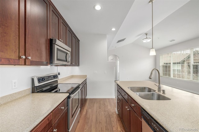 kitchen featuring hardwood / wood-style flooring, hanging light fixtures, stainless steel appliances, sink, and vaulted ceiling