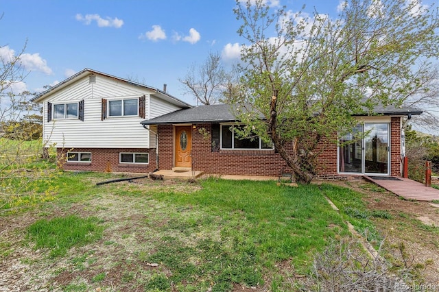 split level home with a front lawn and brick siding