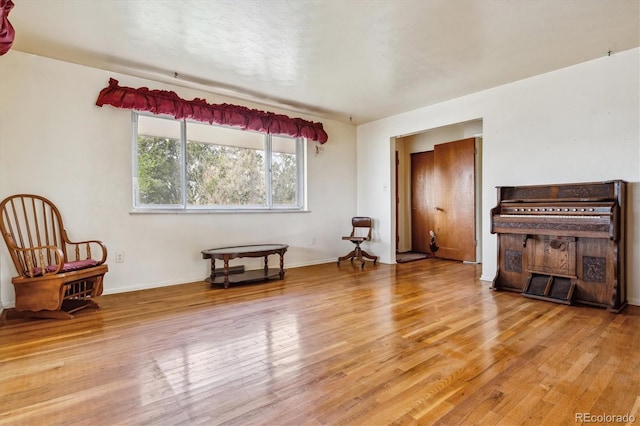 living area featuring baseboards and light wood-style floors