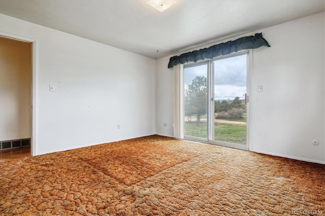 carpeted spare room with visible vents and baseboards