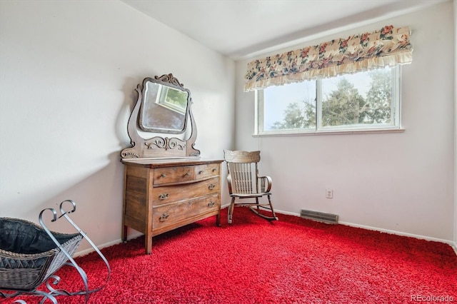 sitting room with carpet floors, baseboards, and visible vents