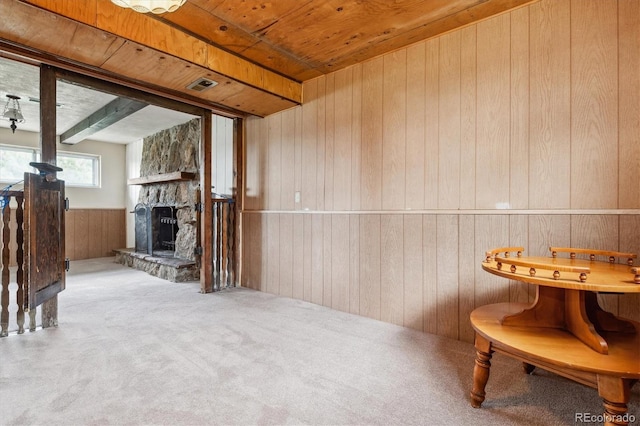 sitting room with wood walls, visible vents, a fireplace, carpet flooring, and wainscoting