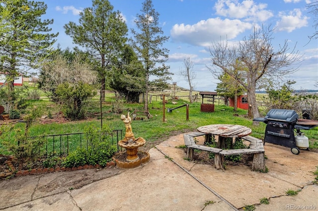 view of patio with fence and a grill
