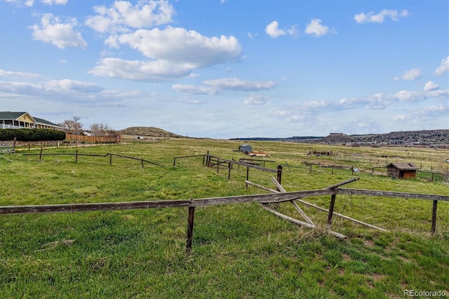 view of yard with a rural view and fence