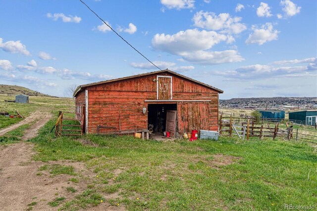 view of barn with a rural view and fence