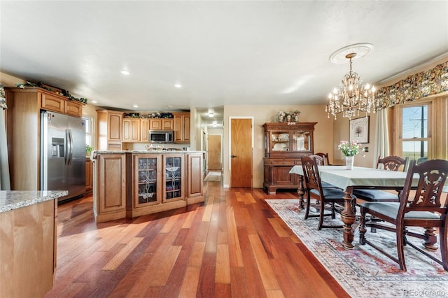 dining area with light wood-type flooring, recessed lighting, a chandelier, and a healthy amount of sunlight