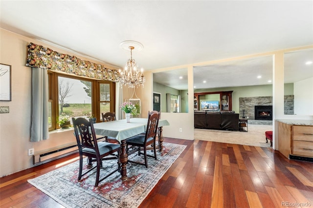 dining area featuring recessed lighting, a fireplace, a chandelier, and dark wood finished floors